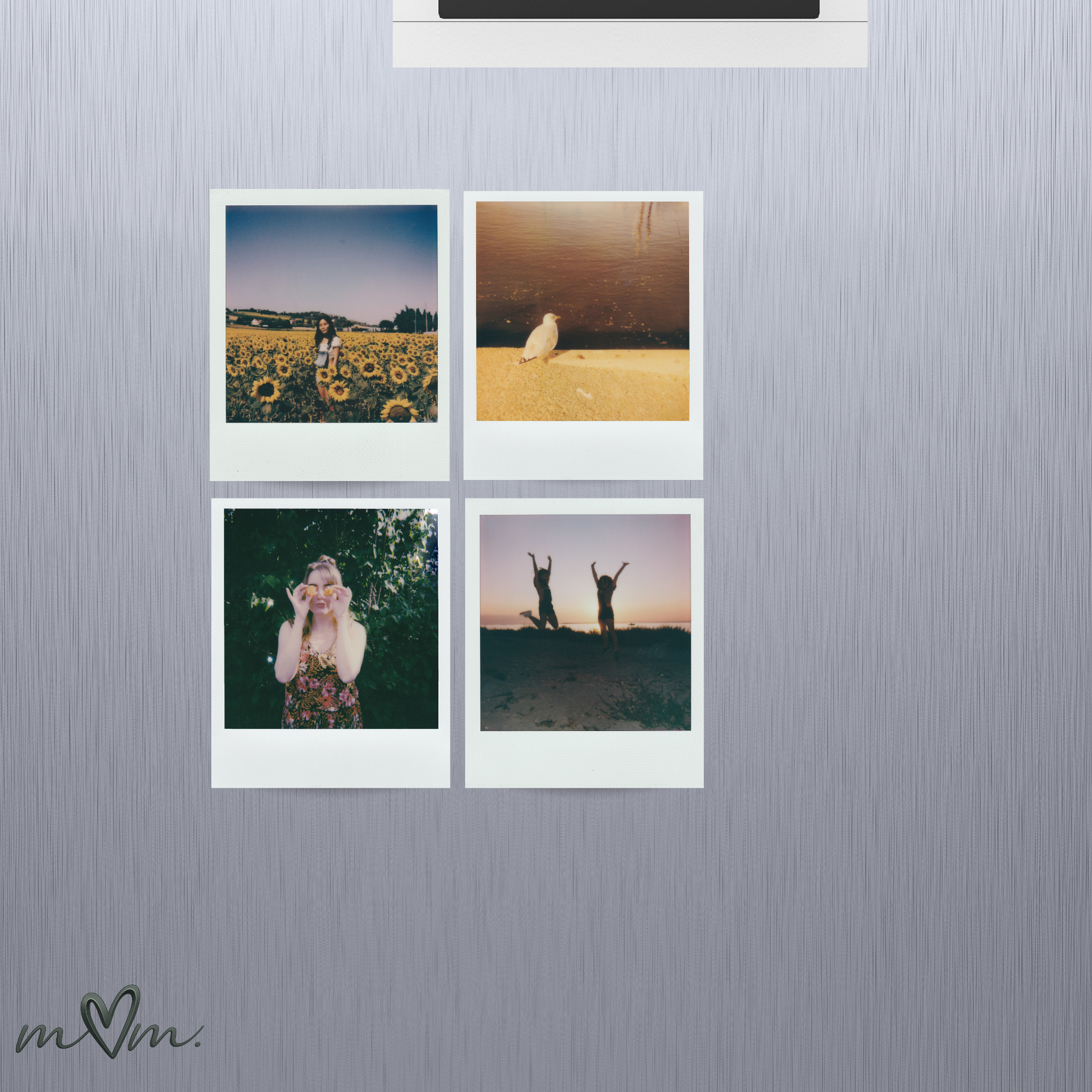 Four photo prints on a metallic wall with 'm2m' logo.