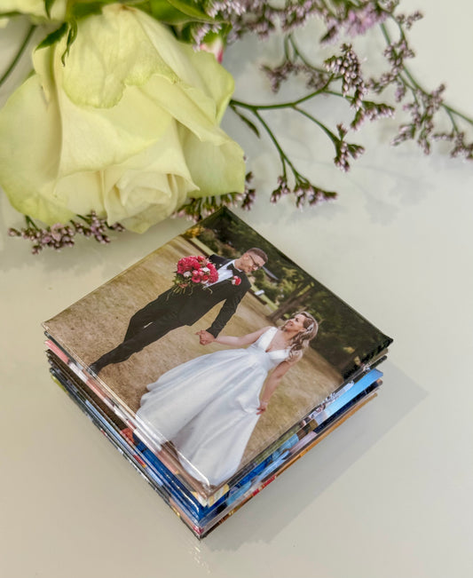 Stack of photo books with a wedding couple on the cover, surrounded by flowers.
