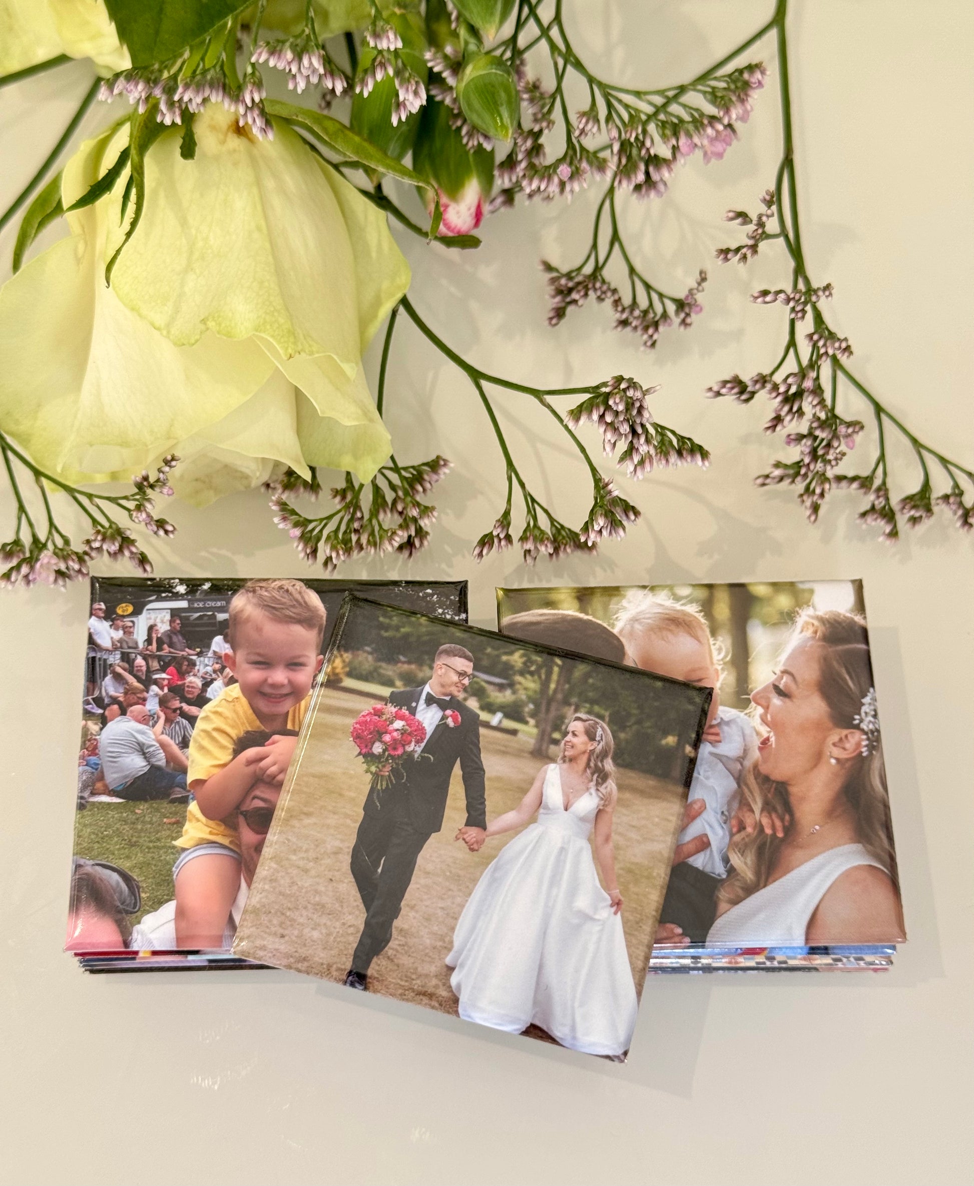 Three photo prints of a couple and a child, with flowers on a light background